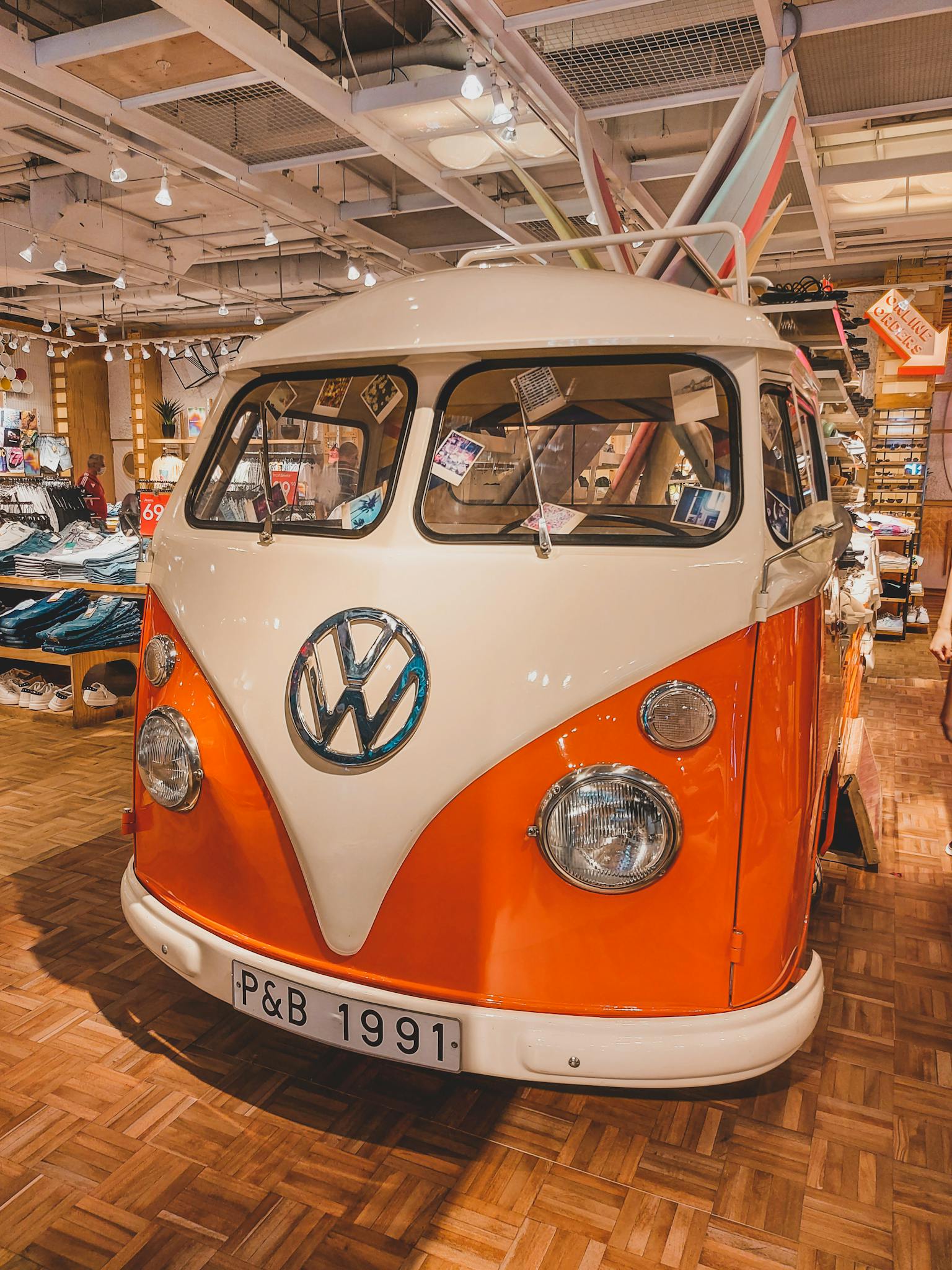 Classic orange and white Volkswagen bus displayed indoors in a Berlin store, capturing retro charm.